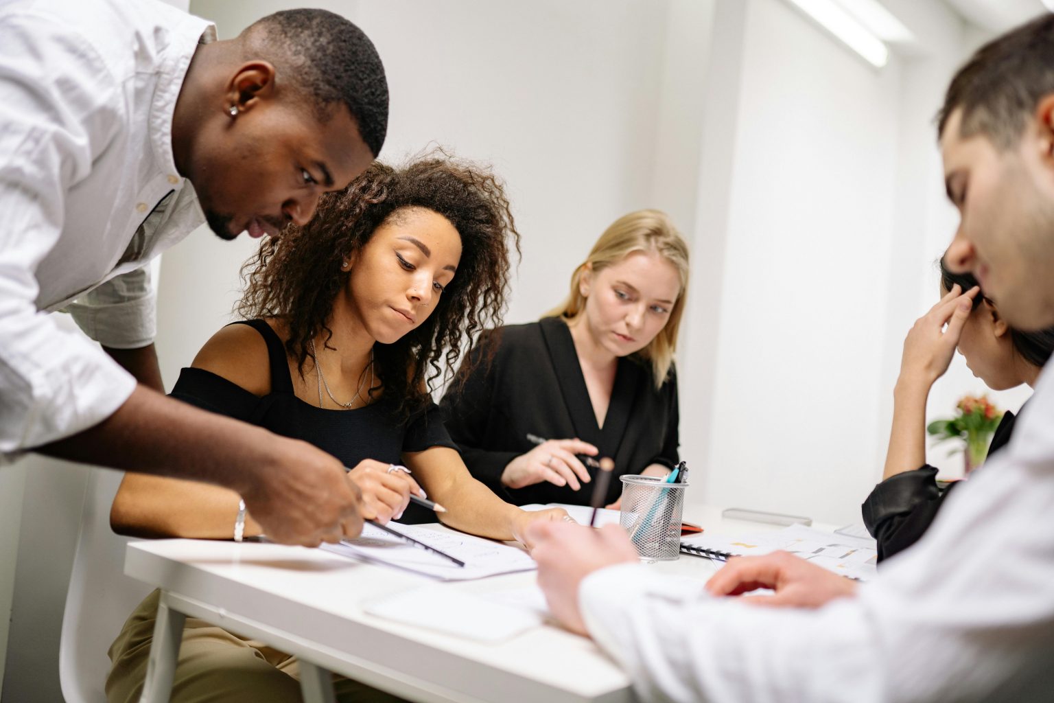 A diverse group of professionals working together in a contemporary office setting, fostering teamwork and creativity.